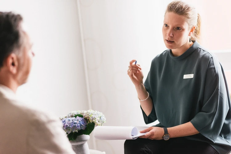 Frau spricht mit Patienten